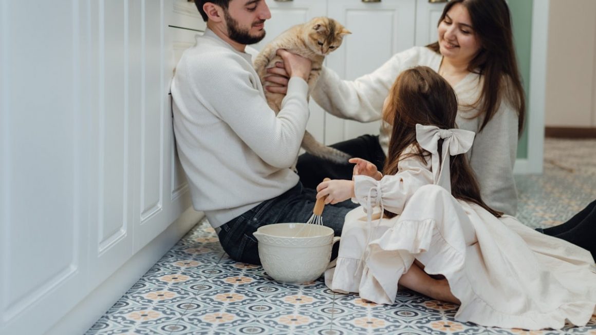 A man and a woman sitting on the floor with a dog